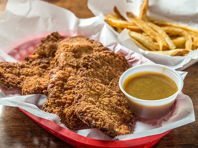 Crispy chicken tenders with fries and dipping sauce at WingBasket, Nashville. Order wings online for delivery.